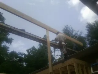 Carpenter setting a ridge beam over a new addition frame — Ice Dam Removal by Roofing Brothers in Princeton